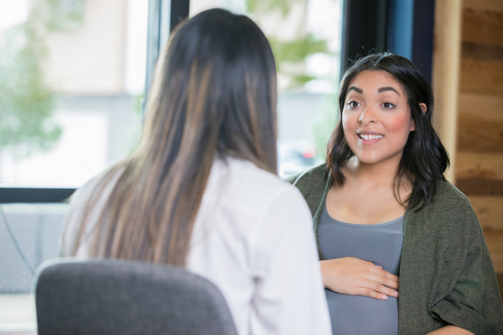 Someone who is pregnant is talking with a medical professional.